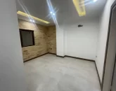 پارکت و کاغذ دیواری و سقف نورپردازی شده با نور سفید و زرد اتاق خواب آپارتمان در چالوس